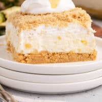 no bake pineapple dream dessert topped with cool whip and pineapple with recipe name at the bottom