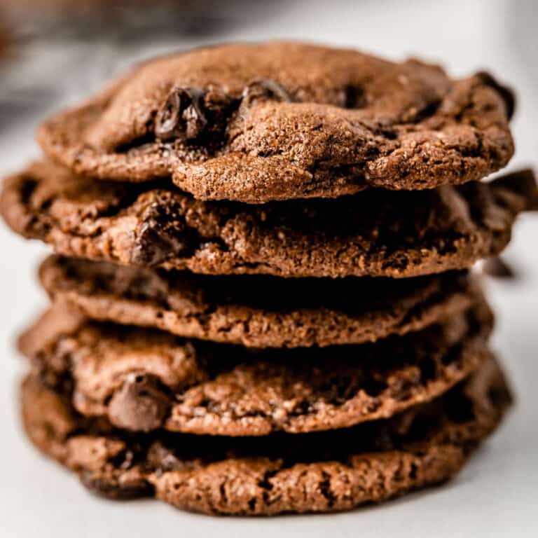square image of a stack of nutty triple chocolate cookies