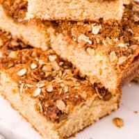 piled of oatmeal sour cream coffee cake squares with recipe name at the bottom
