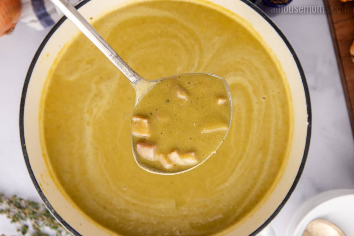 looking down at a ladleful of split pea soup over the pot