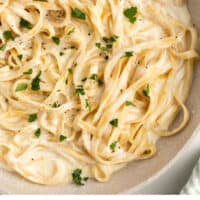 one pot alfredo pasta in a skillet topped with parsley with recipe name at the bottom