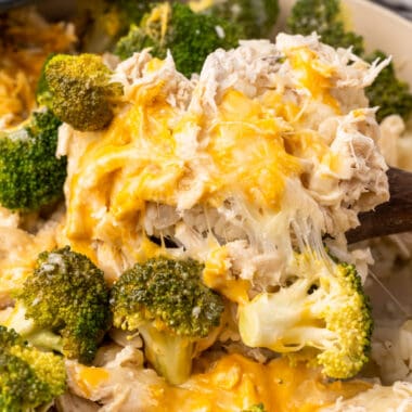 square image of a spoonful of one pot chicken and broccoli rice over the skillet