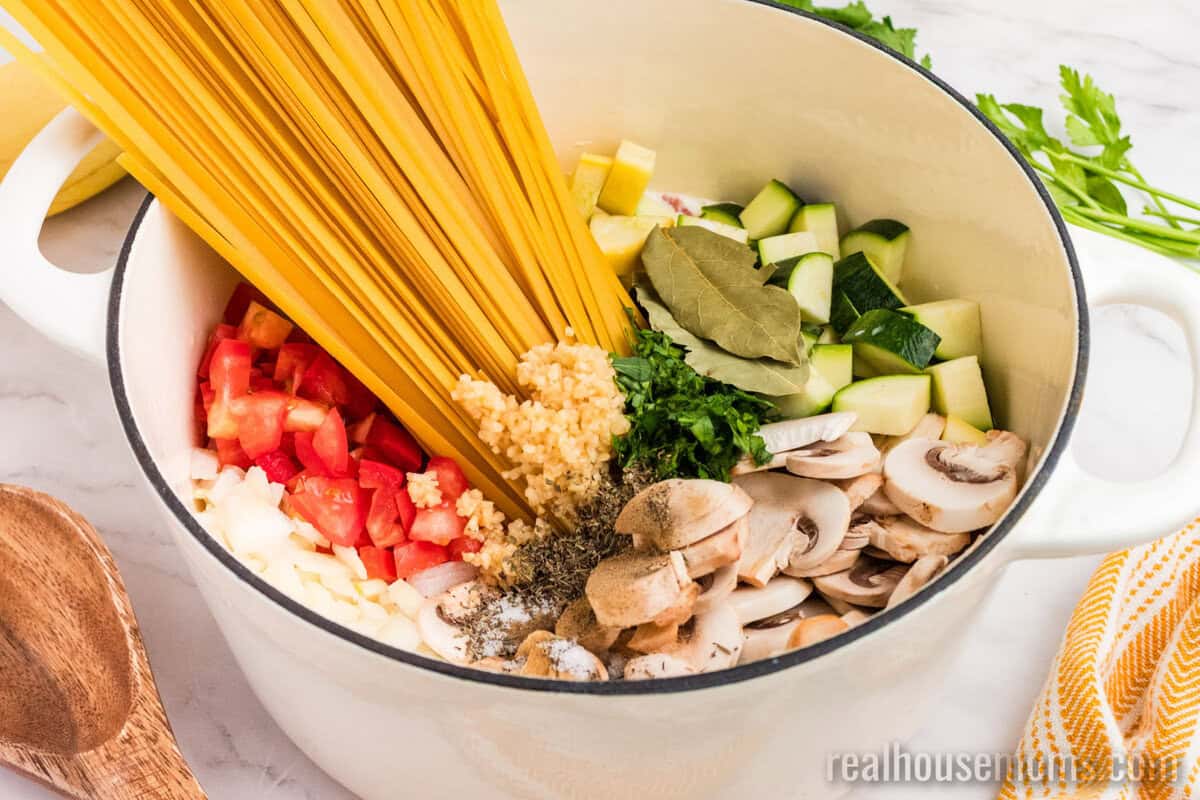 summer vegetable pasta ingredients in a dutch oven before cooking