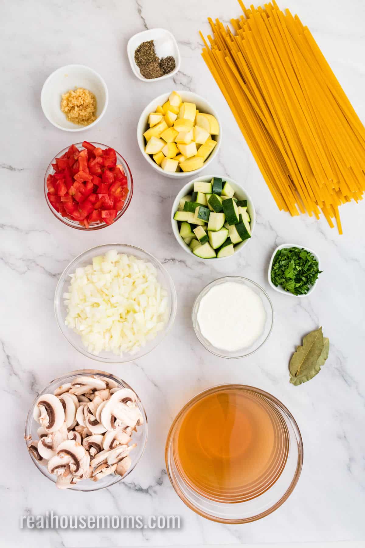ingredients to make vegetable pasta in bowls on a counter