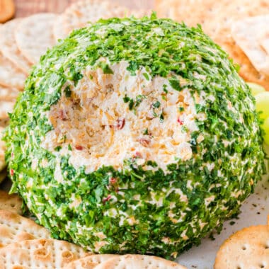 square image of a onion & bell pepper cheese ball with a portion removed to show the inside