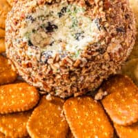 Onion Cranberry Pecan Cheese Ball with a portion taken out to show the filling with recipe name at the bottom