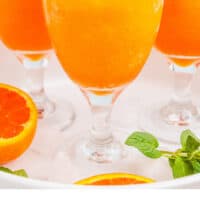 orange vodka slushes on a white serving tray with recipe name at the bottom