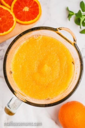 looking down into a blended of orange vodka slush after blending