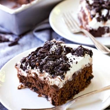 Oreo Poke Cake is an easy dessert recipe that satisfies your sweet tooth! Chocolate cake topped with pudding, Oreos, whipped cream and chocolate syrup is always a win!