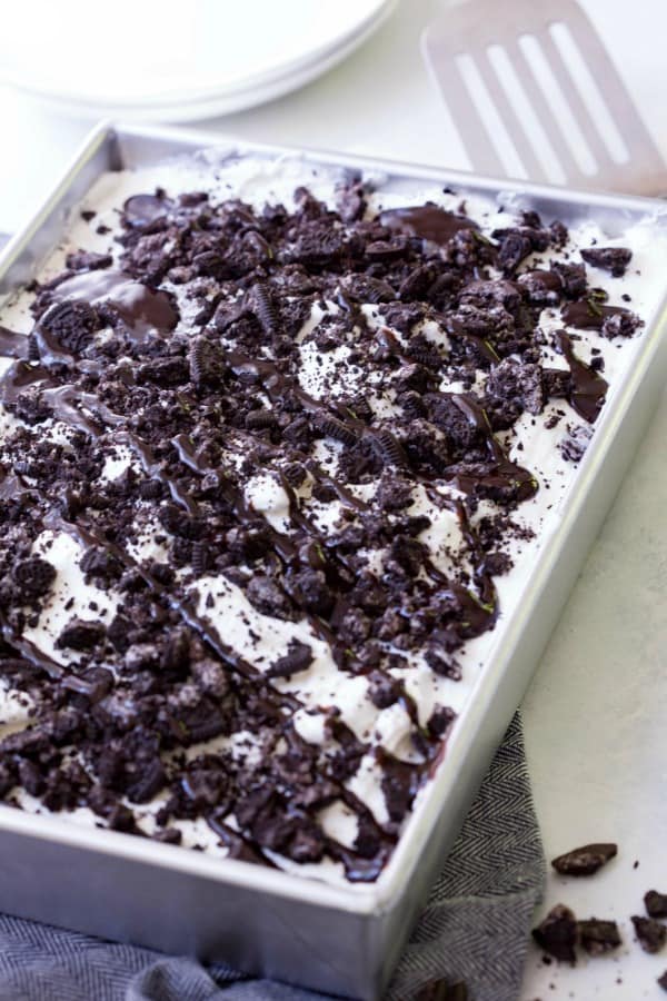 Oreo Poke Cake is an easy dessert recipe that satisfies your sweet tooth! Chocolate cake topped with pudding, Oreos, whipped cream and chocolate syrup is always a win!