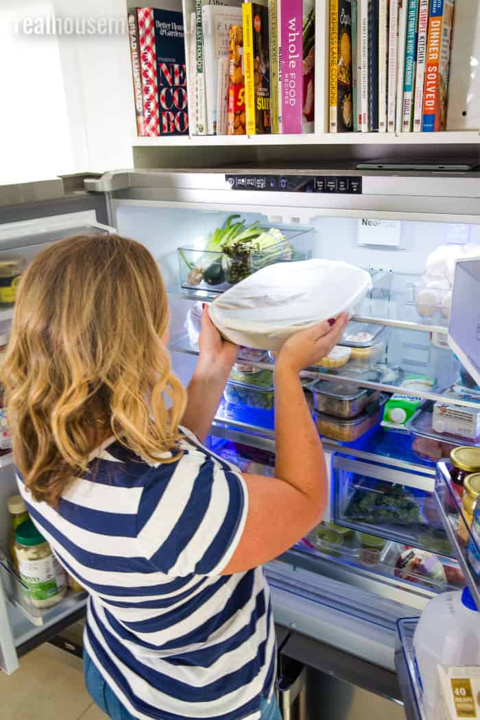 woman putting a covered dish into a Beko refrigerator