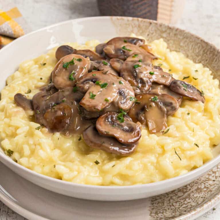 square image of a bowl of parmesan mushroom risotto next to a bowl of sautéed mushrooms and a bowl of parmesan
