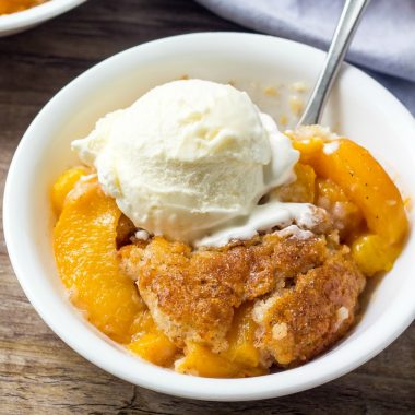 This easy Peach Cobbler Recipe is the perfect summer dessert. With juicy peaches, a hint of cinnamon, and fluffy vanilla cake - it's the best peach cobbler around!