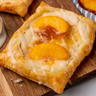 square image of a peach cream cheese danish on a wooden board