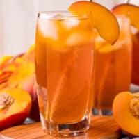 square image of two glasses of peach iced tea with a peach slice for garnish