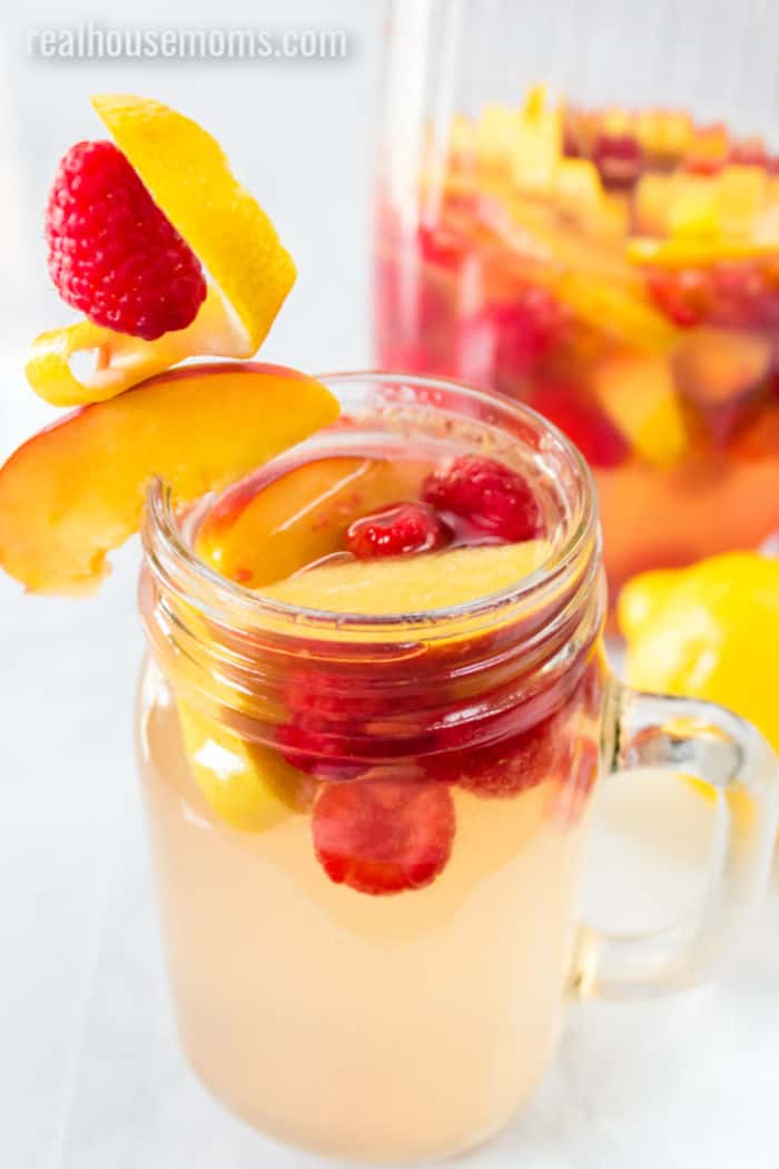 glass of sangria with raspberries and peaches