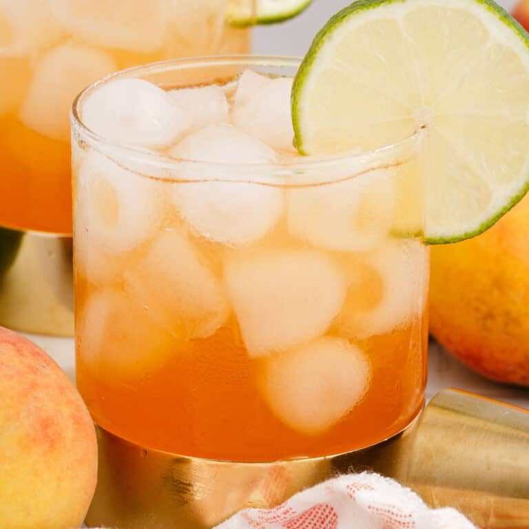 square image of a peach mango rum splash garnished with a lime wheel