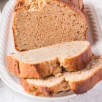 peanut butter bread slices in front of the loaf on a platter with recipe name at the bottom