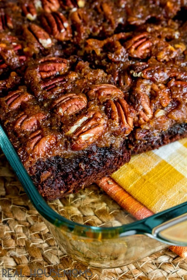 A pan of Pecan Pie Brownies that have been cut into pieces and a few brownies removed.