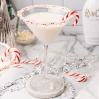 square image of a peppermint bark martini in front of a bottle of rumchata
