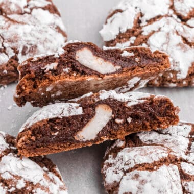 square image of Peppermint Patty Stuffed Chocolate Crinkle Cookies with two halves showing the filling