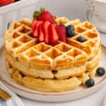 square image of a stack of waffles topped with berries