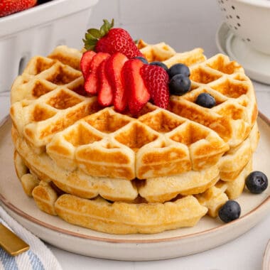 square image of a stack of waffles topped with berries