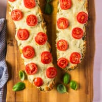 pesto french bread pizza on a cutting board with recipe name at the bottom