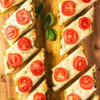 image pesto french bread pizza cut into slices on a cutting board with the title of the post on the top in aqua and black lettering