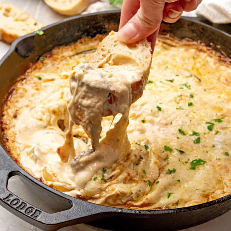 square image of bread slice dipped into philly cheese steak dip