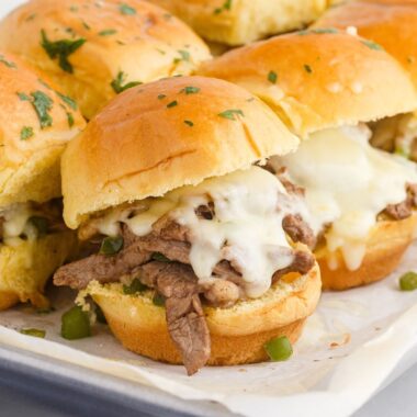 square image of philly cheesesteak sliders on the baking sheet