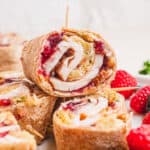 square image of pilgrim pinwheels on a plate with fresh berries