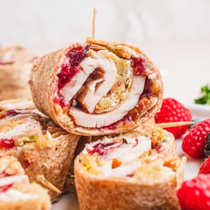 square image of pilgrim pinwheels on a plate with fresh berries