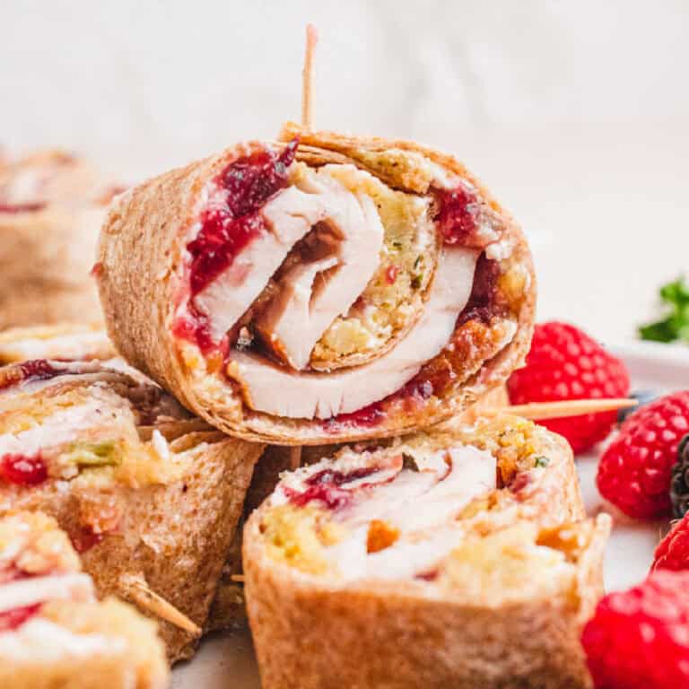 square image of pilgrim pinwheels on a plate with fresh berries