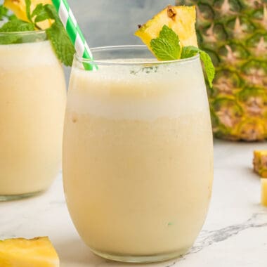 square image of pineapple banana smoothies in glasses with pineapple and mint for garnish