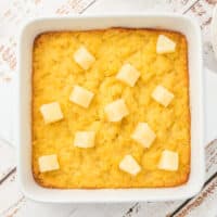 square image of pineapple casserole in a baking dish with pineapple on top
