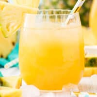 square image of pineapple lemonade in a glass with a straw