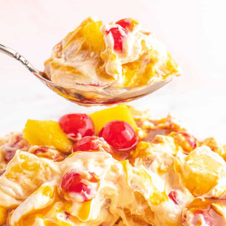 square image of a spoonful of pineapple upside down fluff over the serving bowl