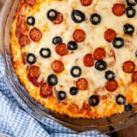 pizza dip topped with pepperoni and olives with recipe name at the bottom