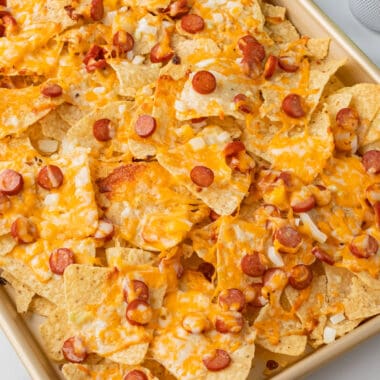 square image of pizza nachos on a sheet pan