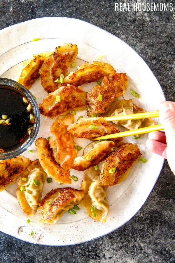 pot stickers on a plate with dipping sauce