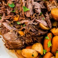 pressure cooker pot roast shredded and served on a platter with carrots and potatoes with recipe name at bottom
