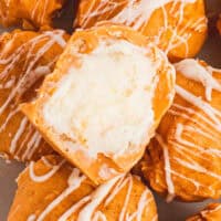 image of pumpkin cheesecake balls on a image of plate with one cut in half to show the cheesecake filling inside the title of the post on top of the image in blue and black lettering