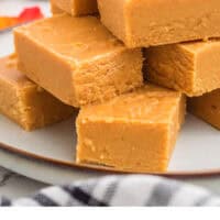 pumpkin fudge squares piled on a plate with recipe name at the bottom