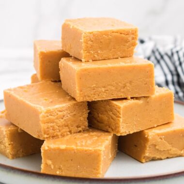 square image of pumpkin fudge pieces stacked on a plate