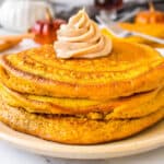 square image of pumpkin pancakes stacked with pumpkin spice butter on top