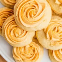 looking down at pumpkin spice sugar cookies piled on a plate with recipe name at the bottom