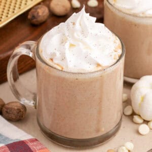 square image of pumpkin white hot chocolate topped with whipped cream in a glass mug