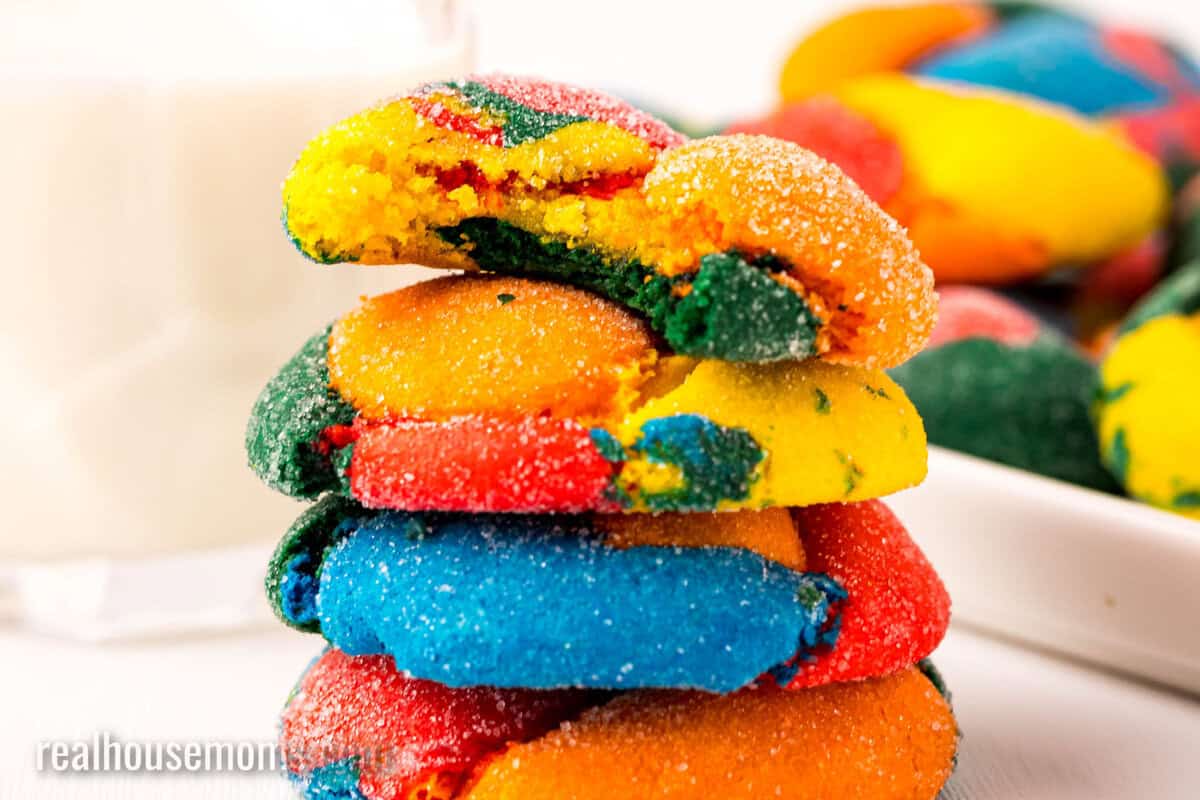 stack of rainbow cake mix cookies with a bite taken out of the top cookie