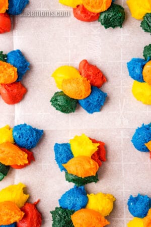 dollops of different colored cake mix cookie dough arranged together on a baking sheet